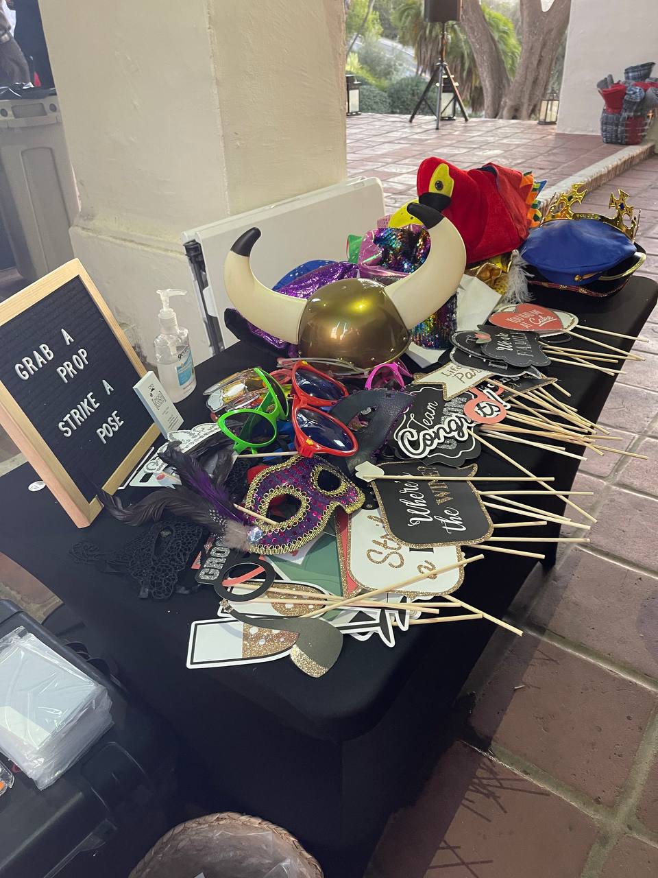 Curated photo booth prop table with glasses, hats and signs