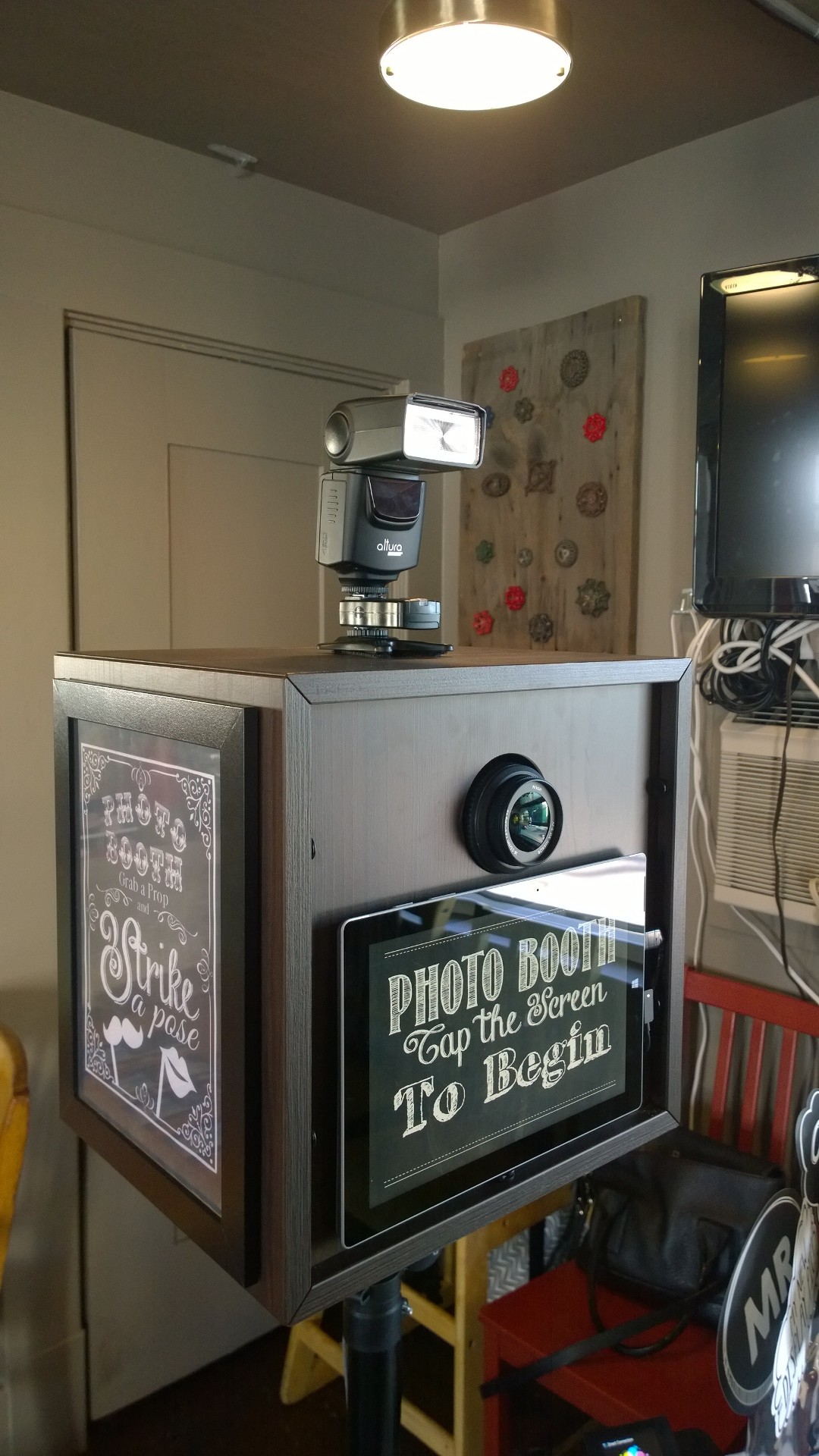 Wooden cabinet photo booth with Strike a Pose sign